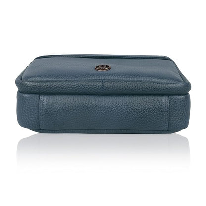 A dark teal blue pebbled leather pouch with a small round metal button closure on the front, shown against a plain white background with a soft reflection below.