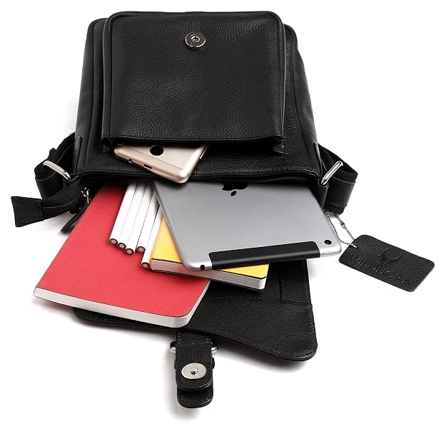 Black leather crossbody bag with various items including a tablet, phone, and books on a white background