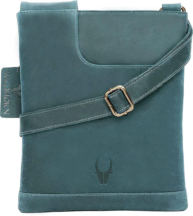A teal blue leather crossbody bag with a matching adjustable strap and a gold-tone buckle, featuring a debossed bull skull logo on the front.