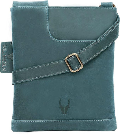 A teal blue leather crossbody bag with a matching adjustable strap and a gold-tone buckle, featuring a debossed bull skull logo on the front.