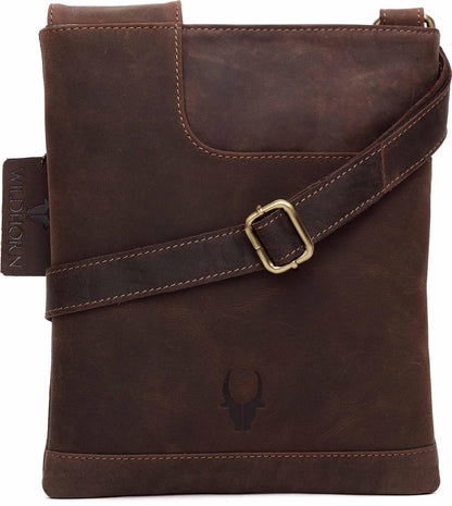 A dark brown distressed leather crossbody bag with a matching leather strap and a gold-tone buckle, featuring a debossed bull skull logo on the front.