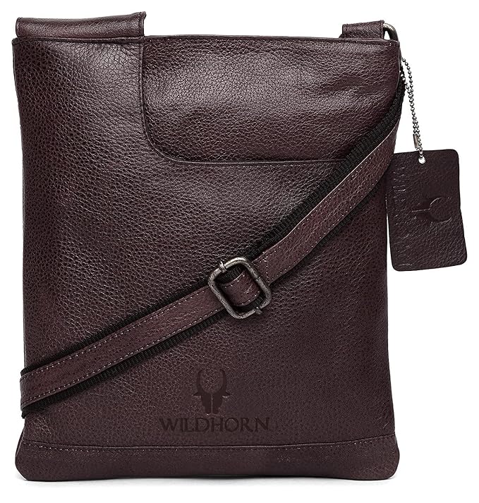 Black textured leather crossbody bag with a diagonal strap, a hanging brand tag, and a debossed logo on the front, shown on a white background.