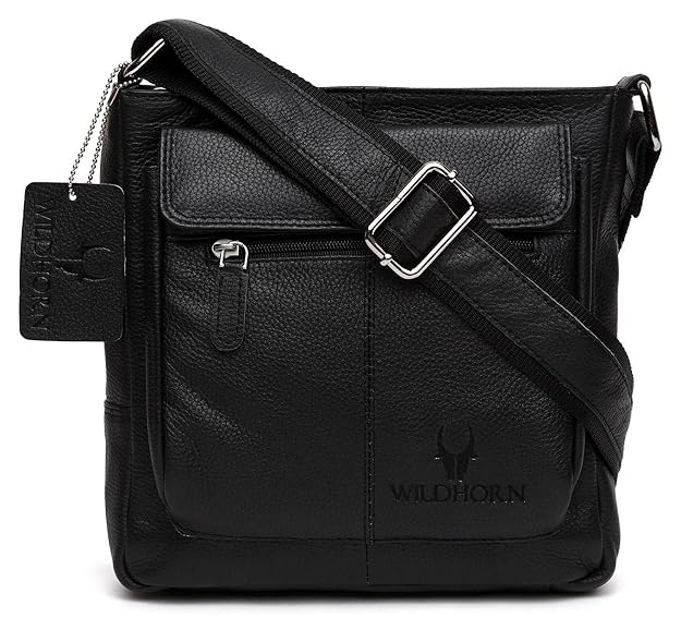 Black pebbled leather crossbody bag with a front flap pocket, silver buckle strap, and embossed WILDHORN logo on a white background.
