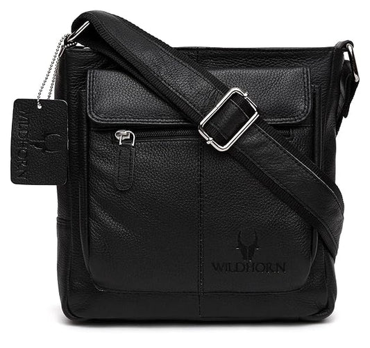 Black pebbled leather crossbody bag with a front flap pocket, silver buckle strap, and embossed WILDHORN logo on a white background.