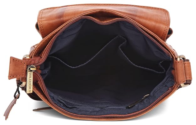 A brown leather crossbody bag shown open from the front, displaying a dark navy blue interior lining and a zippered compartment. The brand name 'MILANO ITALY' is visible on a small gold tag attached to the zipper pull.