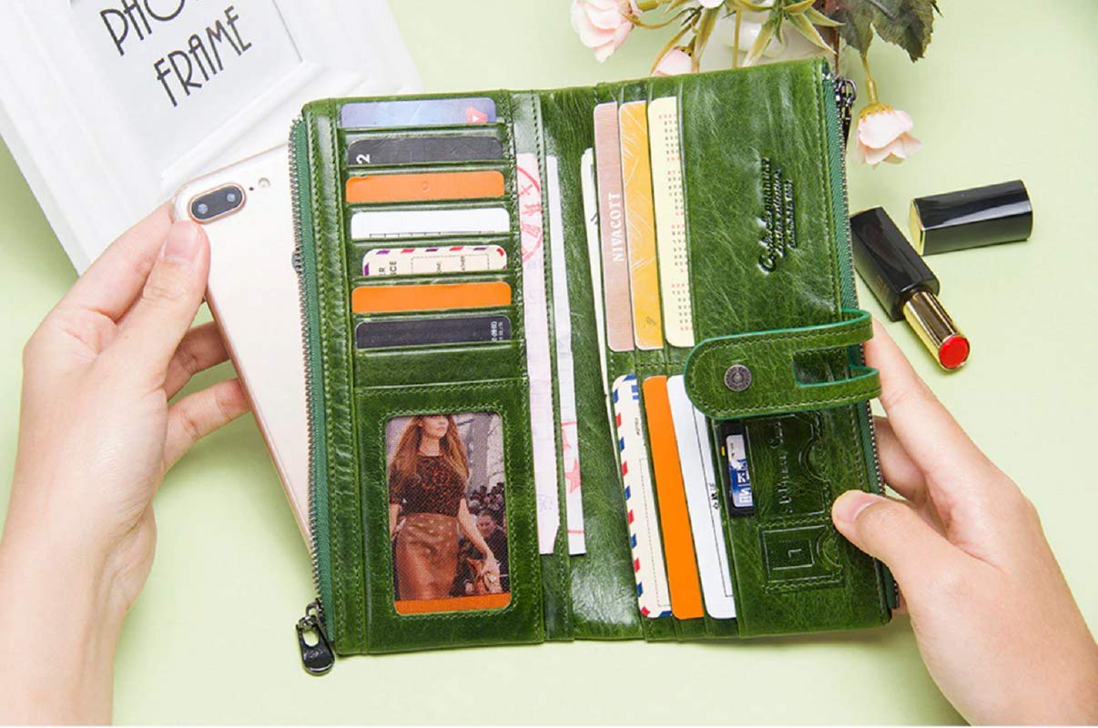 A green leather wallet phone case held open by two hands, showing multiple card slots, a phone slot, and a photo ID window. A white smartphone is partially inserted on the left, with lipstick and flowers as props on a pale green background.